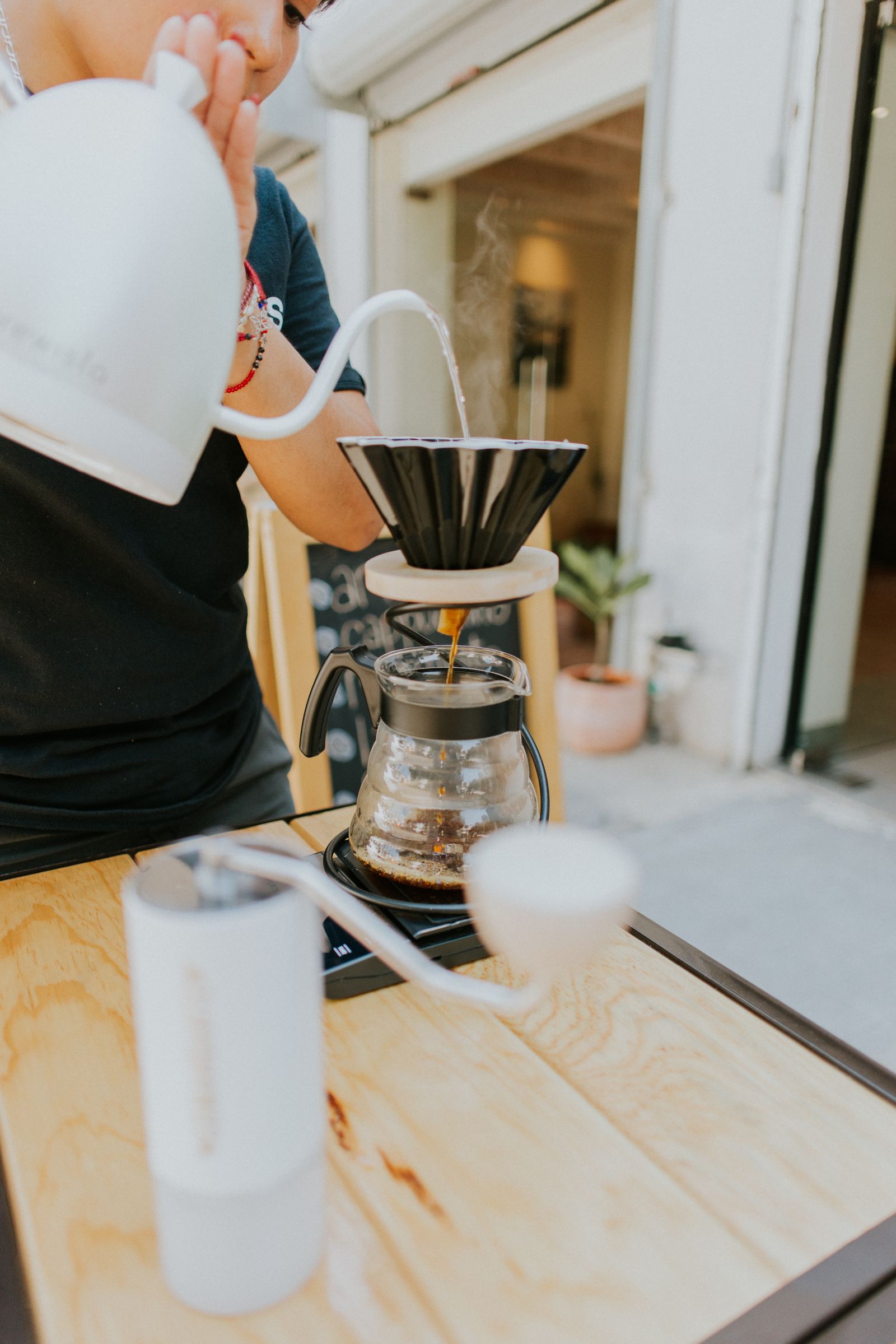 Barista making pour-over coffee with a kettle